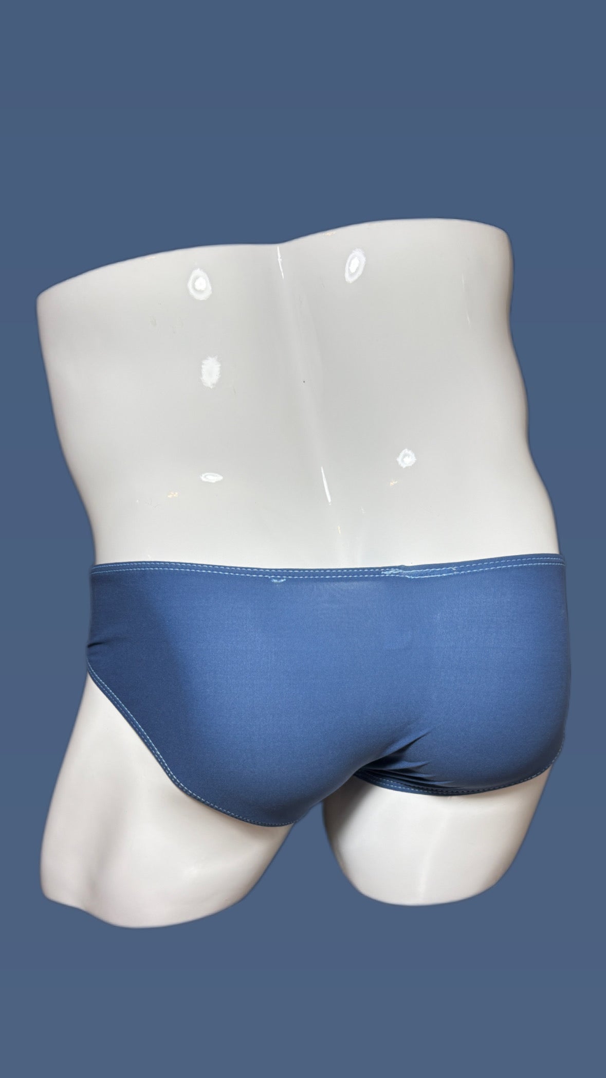 Blue underwear on a white mannequin against a blue background