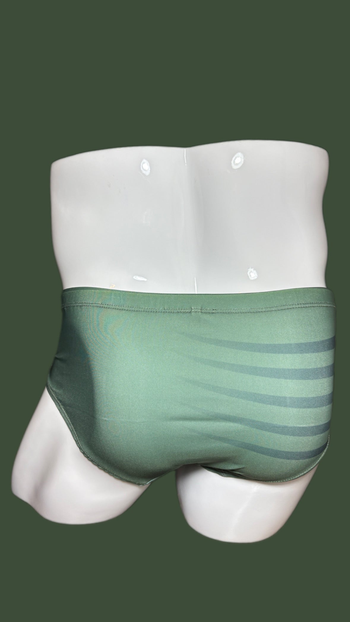 Green swimwear on a mannequin against a green background