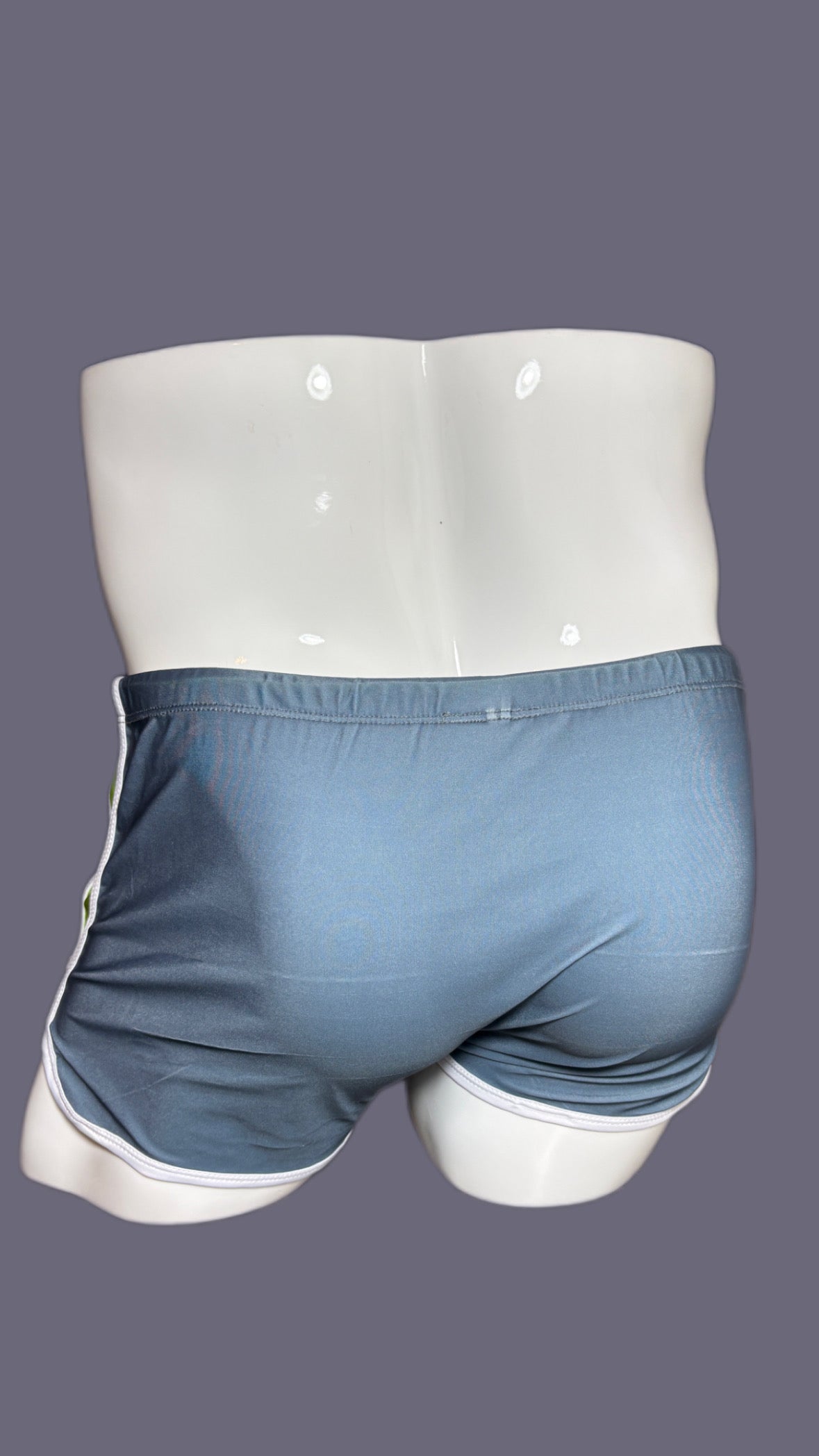 Gray shorts with green drawstring and 'onip' branding on a mannequin against a gray background