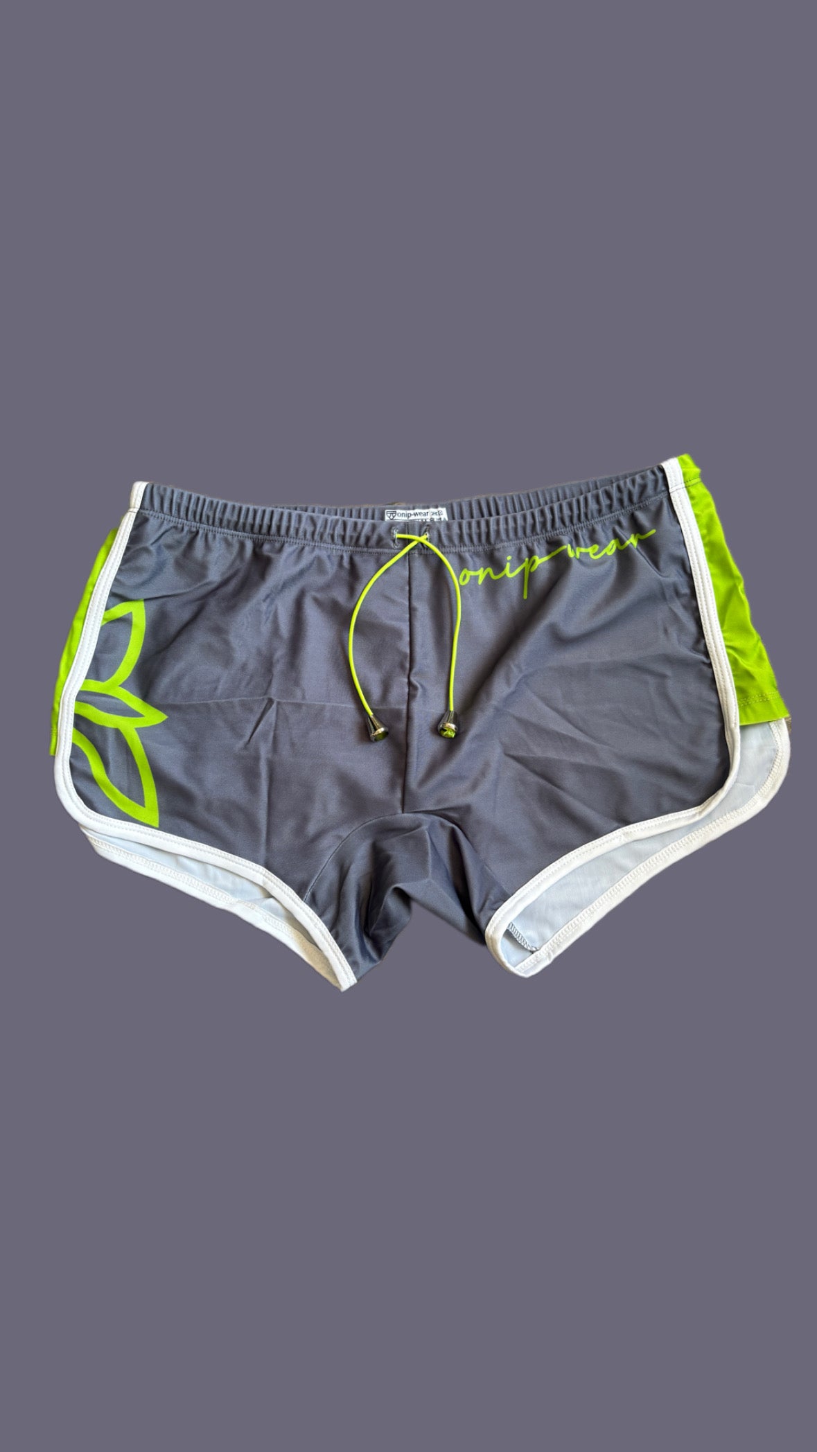 Gray shorts with green drawstring and 'onip' branding on a mannequin against a gray background