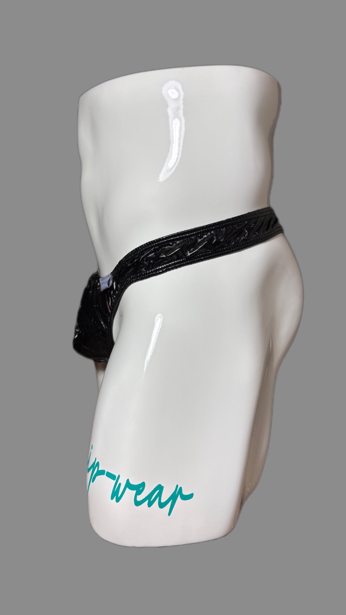 Black thong on a white mannequin against a gray background