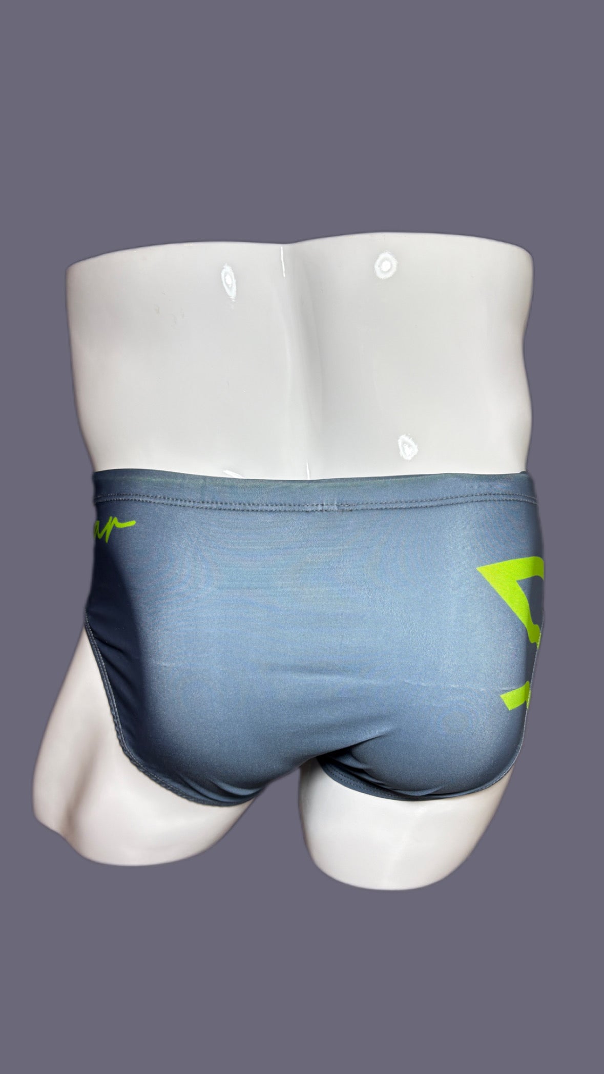Gray swim briefs with green accents on a mannequin against a gray background