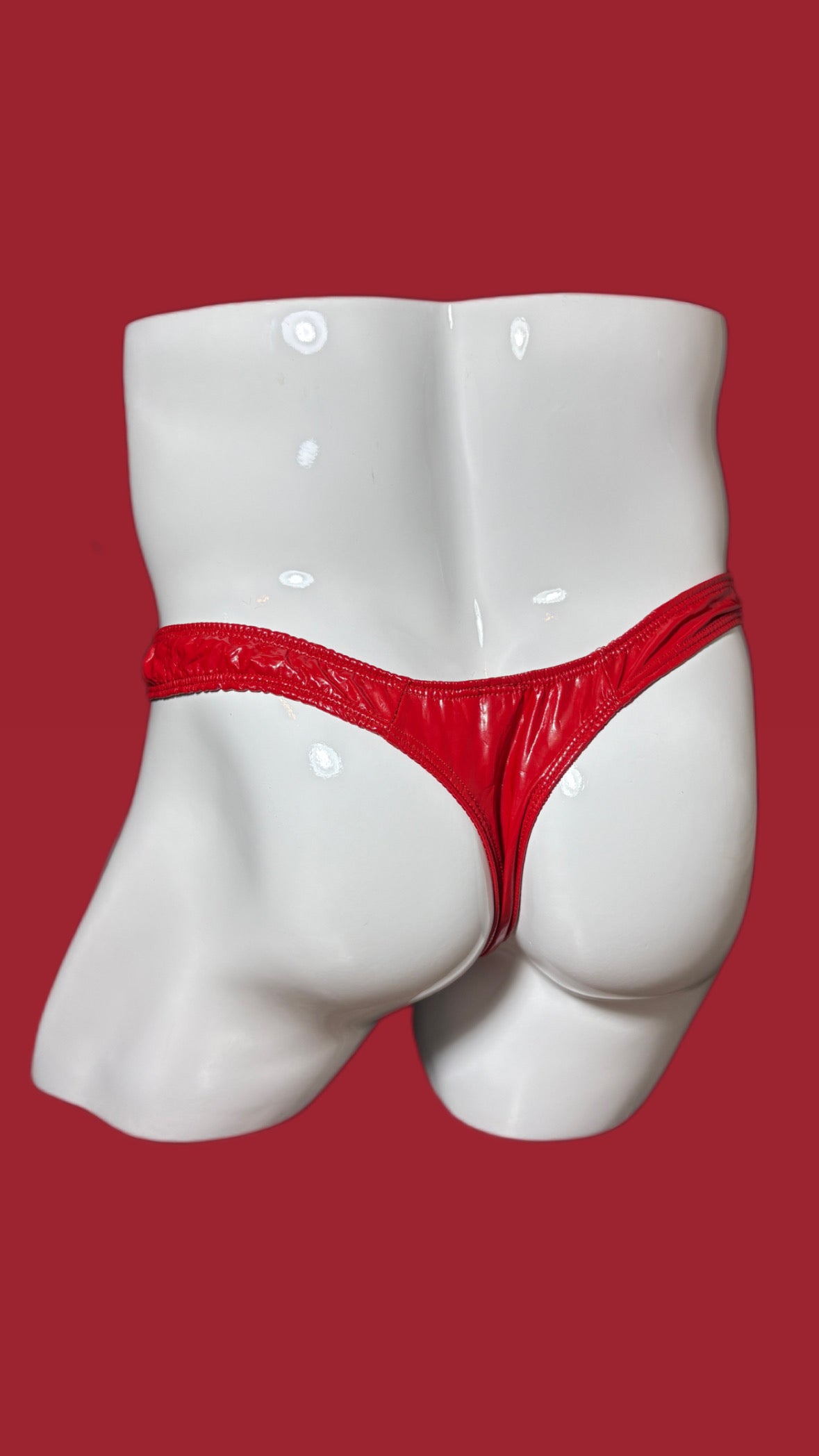 Red men's underwear on a white mannequin against a red background