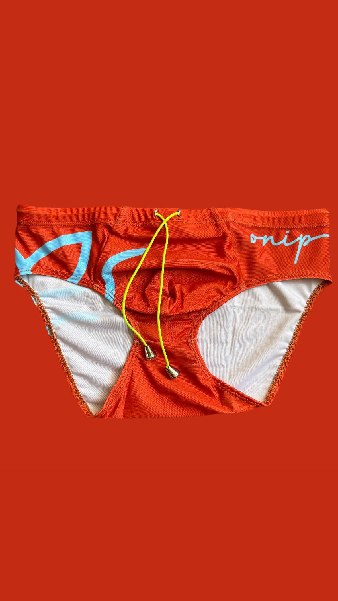 orange swim brief with blue accents and a yellow drawstring on an orange background