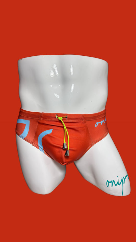 orange swim shorts with branding on a mannequin against an orange background