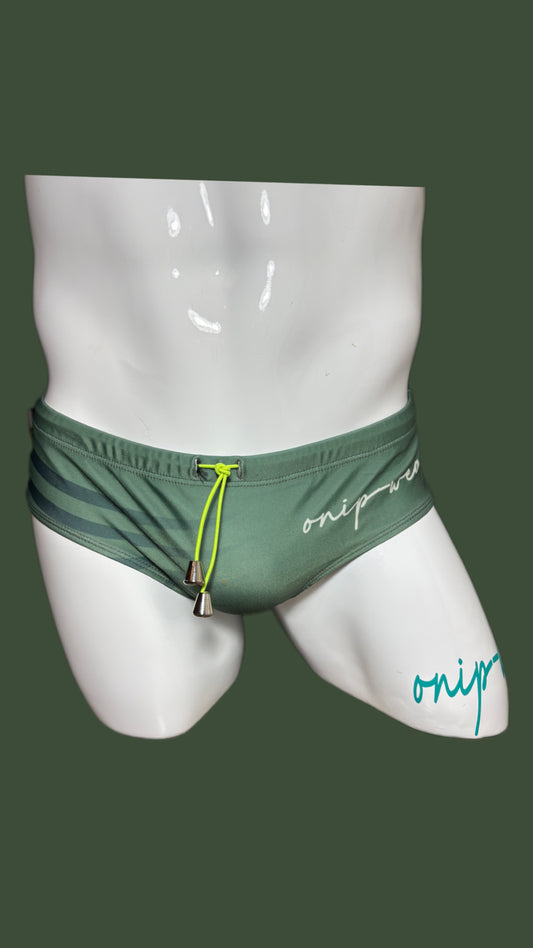 Green swim briefs on a mannequin with 'onip' branding against a dark green background